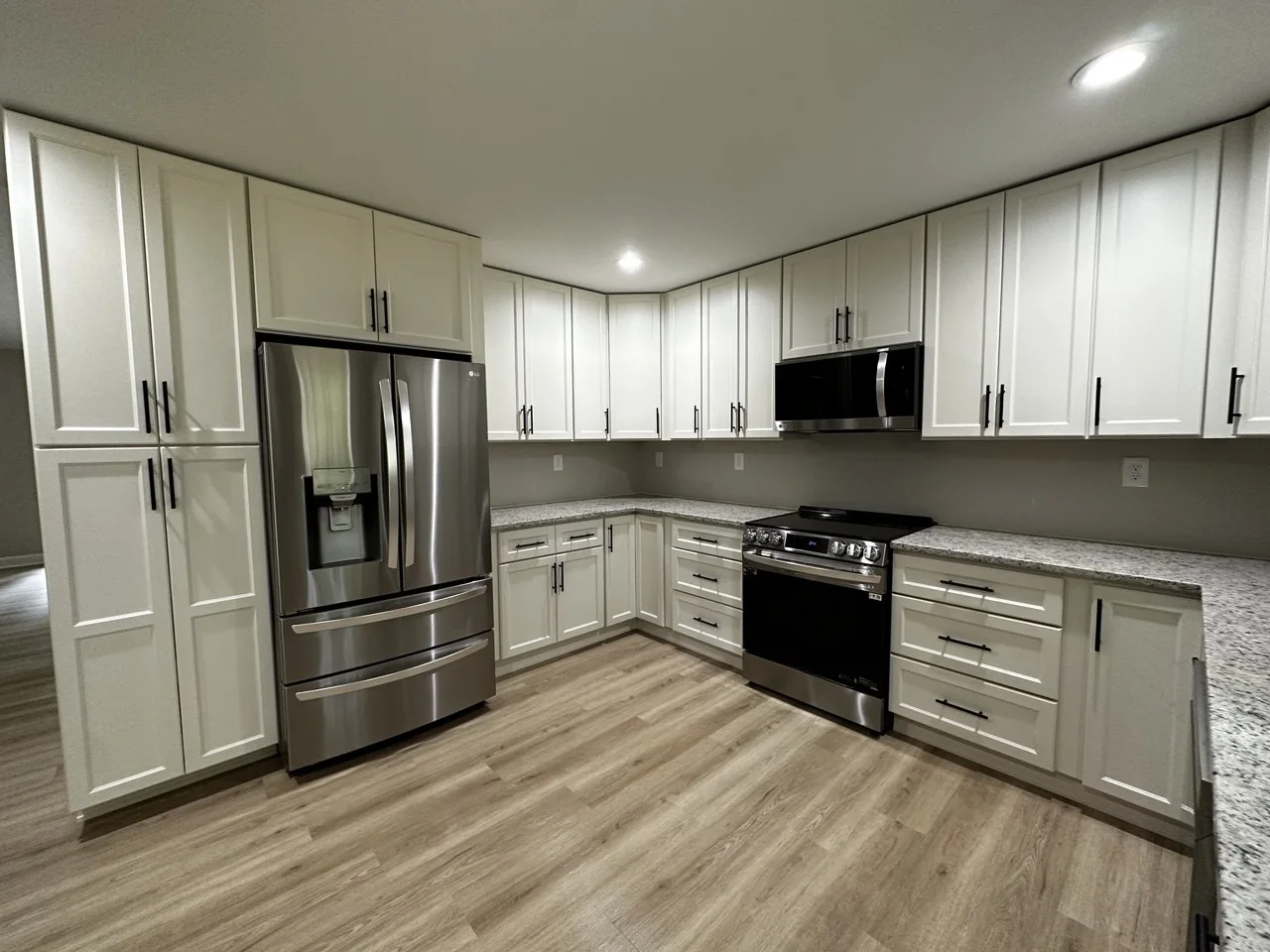 Finished kitchen with white shaker cabinets and stainless appliances